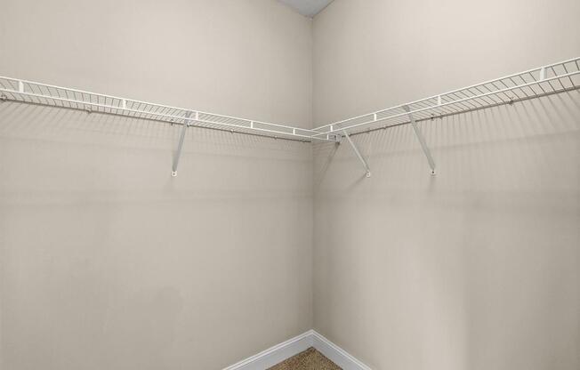 Empty white closet with a white shelf.