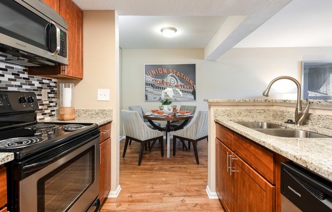 the kitchen and dining area of a home with a table and chairs