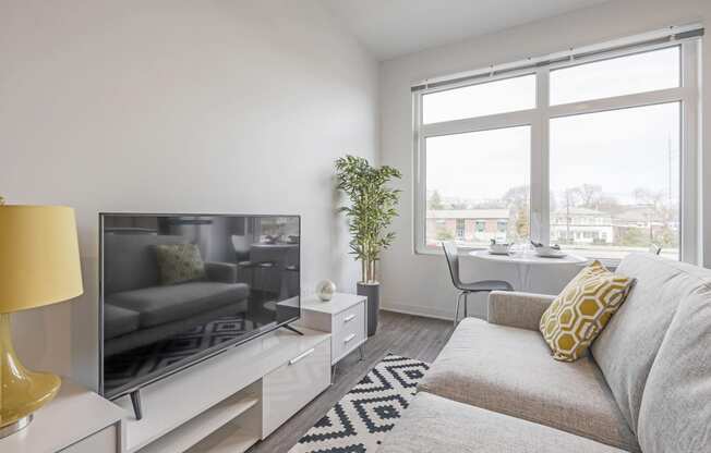 a living room with a couch and a tv and a window