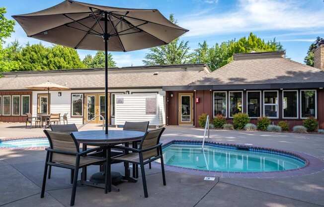 A patio with a table and chairs and an umbrella is shown.