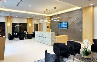 a modern hotel lobby with a reception desk and chairs  at Douglas Enclave, Miami