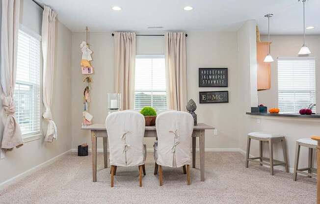 A dining room with a table and chairs.