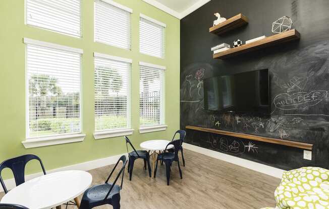 fitness center child room with tables chairs and blackboard