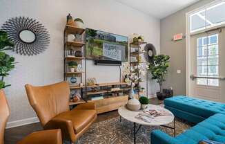 A living room with a brown leather chair, a blue sofa, and a coffee table with a vase of flowers on it.