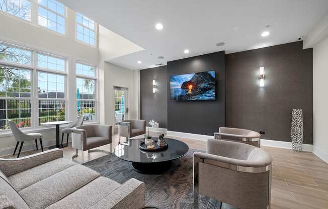 A modern living room with a large screen TV and comfortable seating.