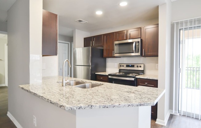 Beautiful upgraded kitchen with stainless steel appliances, granite countertops and walnut brown cabinetry, located at The Legends at Eagle Mountain Lake -A beautiful lakeside community.