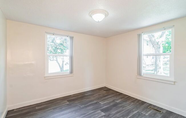 Bedroom with two windows at Sutterfield Apartments in Providence RI