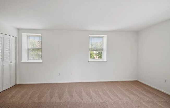 Bedroom with plush carpeting and large closets