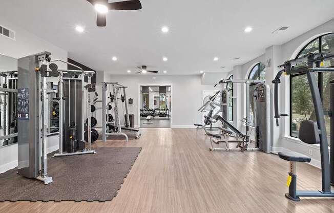 a home gym with exercise equipment and a ceiling fan