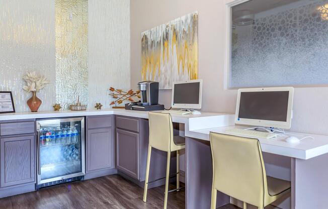 a desk with a computer and a chair in a room