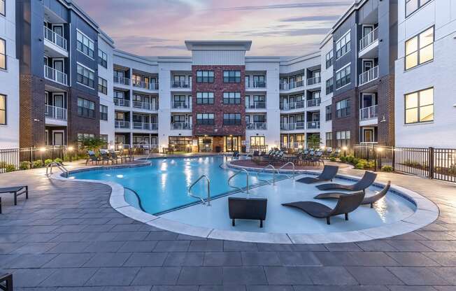 an empty swimming pool in an apartment building at dusk