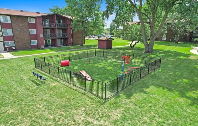 a fenced in dog park in the middle of a yard