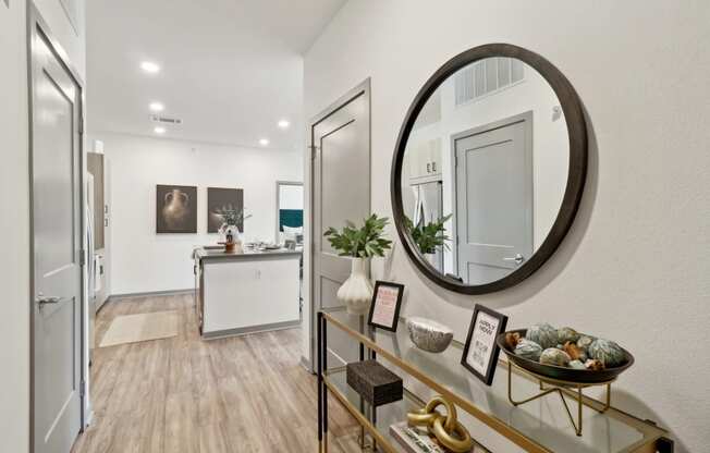 a living room with an oval mirror and a glass display case at The Depot in The Depot Raymore, MO 64083