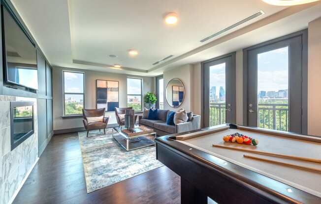 Resident sky lounge facing a pool table and sitting area complete with a television and fireplace.