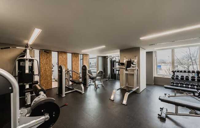 A gym with a variety of equipment including weights and machines.