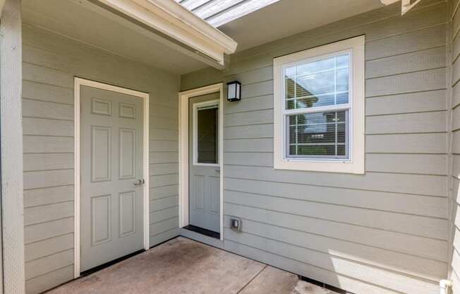 the hallway of the house with a white door and a window