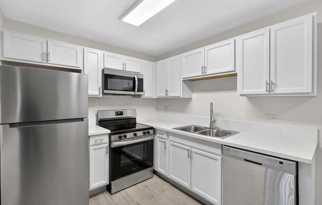 A kitchen with white cabinets and stainless steel appliances.