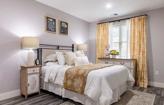 A bedroom with a large bed and a nightstand with a lamp.
