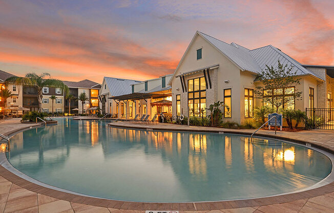 a large swimming pool in front of a house with a sunset in the background  at Cabana Club - Galleria Club, Jacksonville