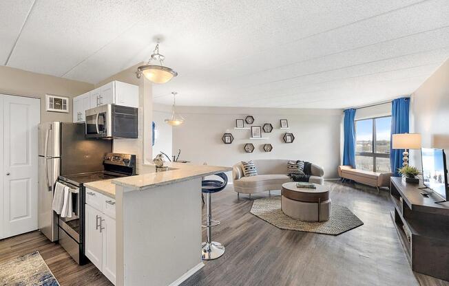 a kitchen and living room with a counter top at Troy Place Apartments - Troy, MI, Troy, Michigan