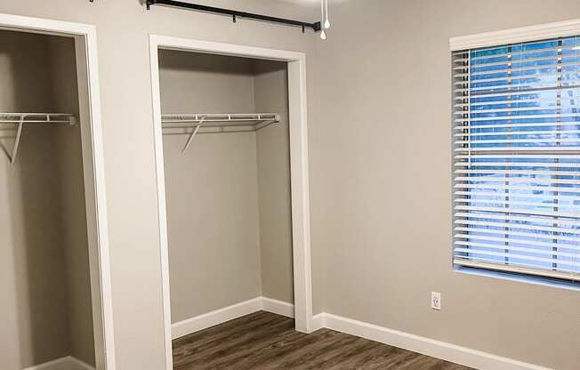 an empty bedroom with a closet and a ceiling fan with wood flooring