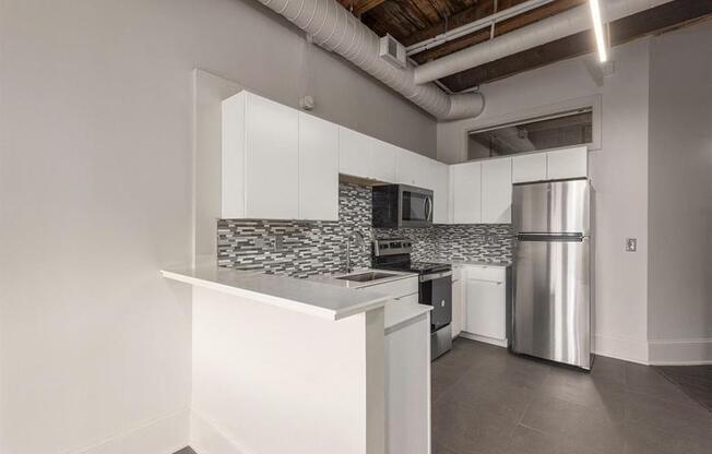 a kitchen with white cabinets and a stainless steel refrigerator