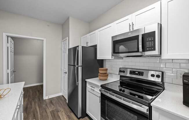 a kitchen with stainless steel appliances and white cabinets