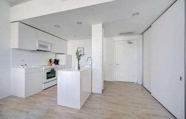 a white kitchen with white cabinets and a sink