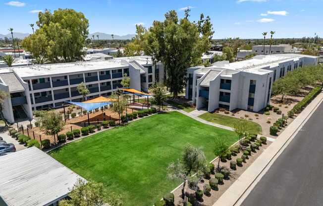 A large building complex with a green lawn in front.