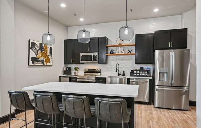 A modern kitchen with a white island and black cabinets.