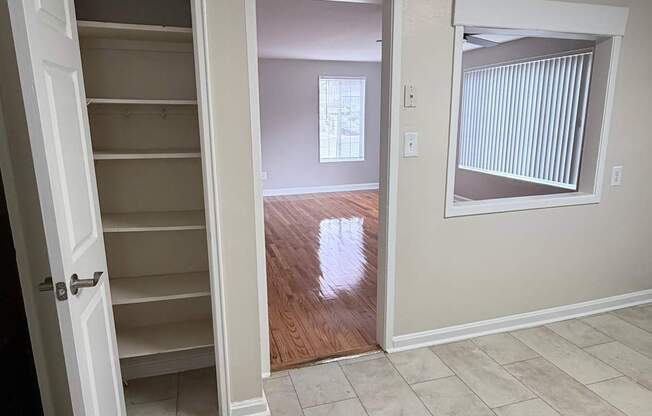 A room with a white door and a window with blinds.