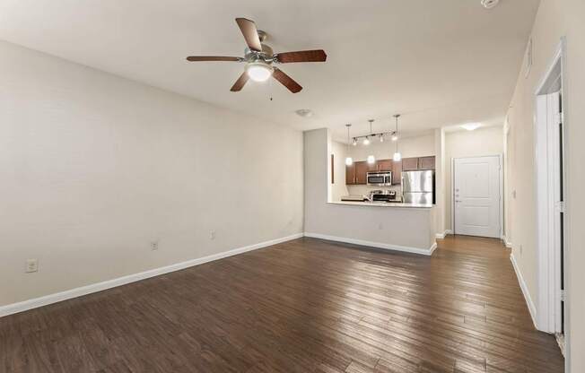 A room with a ceiling fan and wooden flooring.