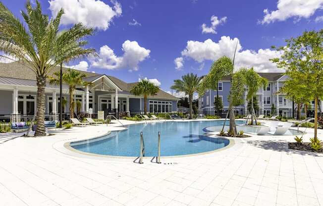 A swimming pool surrounded by palm trees and a white tiled patio.