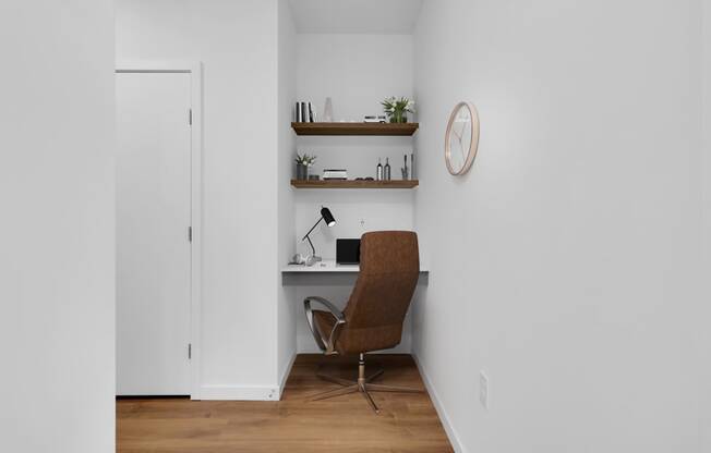 a home office with a desk and a chair and a clock on the wall