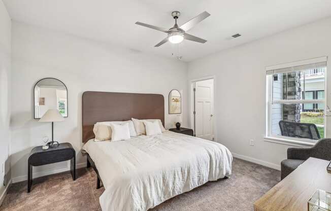 a bedroom with a large bed and a ceiling fan