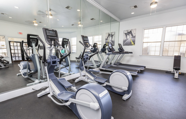 View of Fitness Center, Showing Cardio Equipment, Weight Bench, and Wall of Mirrors at Stonebriar of Frisco Apartments