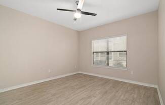 a bedroom with a ceiling fan and a window