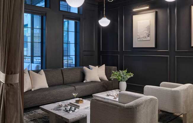 A living room with a grey sofa, a coffee table, and a large window.