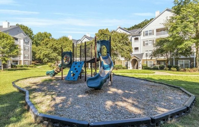 a playground in a park with houses in the background at Marina Point, Tennessee