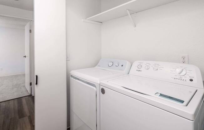 A white washing machine and dryer in a small room.