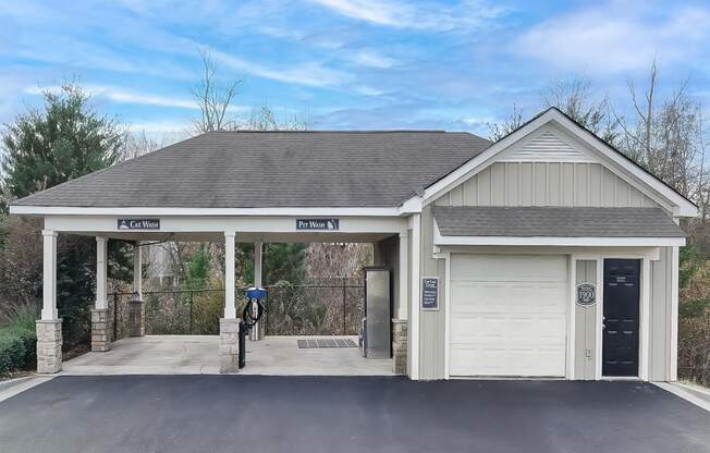 the front of a garage with a driveway and a white door