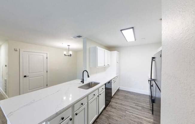 A kitchen with white countertops and a sink.