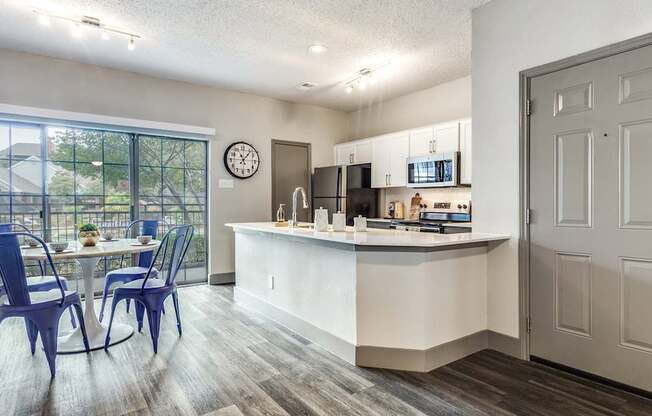 A kitchen with a dining table and chairs is shown.