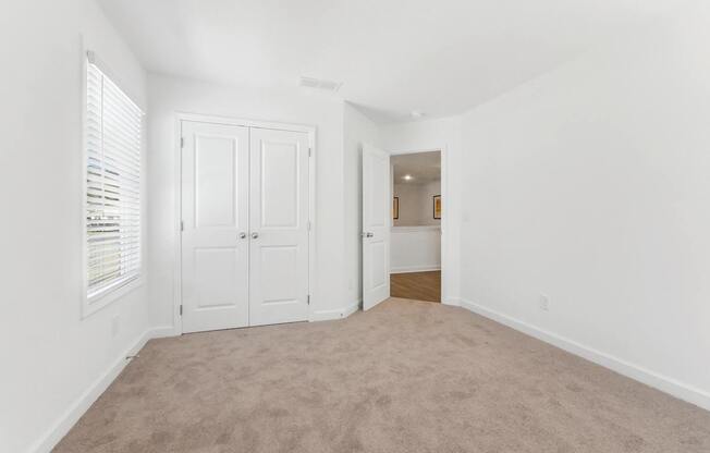 an empty living room with white walls and white doors and carpet