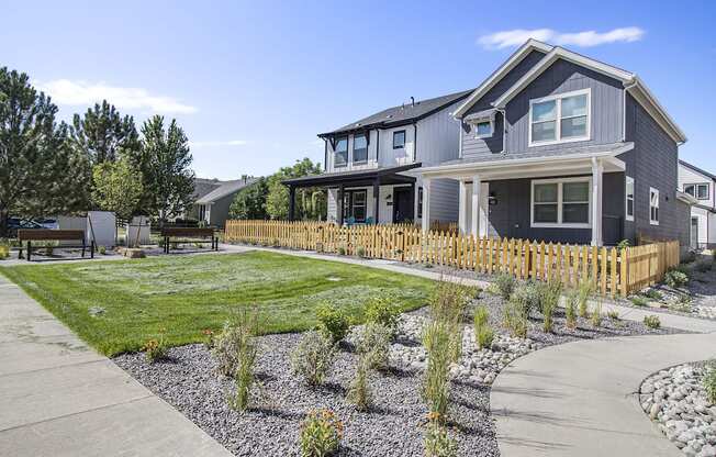 a blue house with a yard and a sidewalk