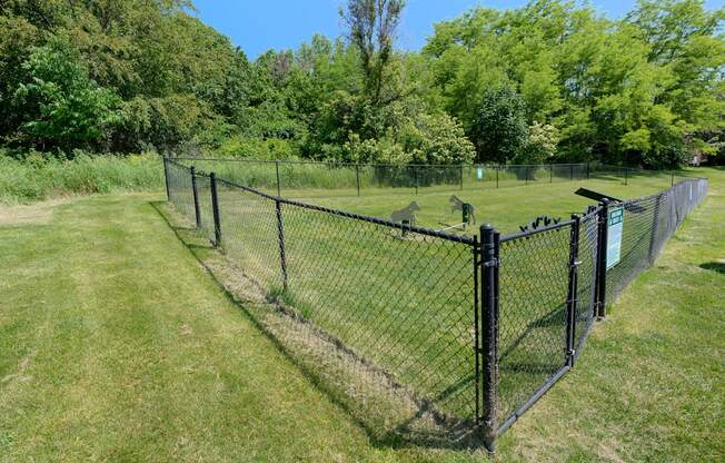 a chain link fence with a fence post and a wire fence in a field
