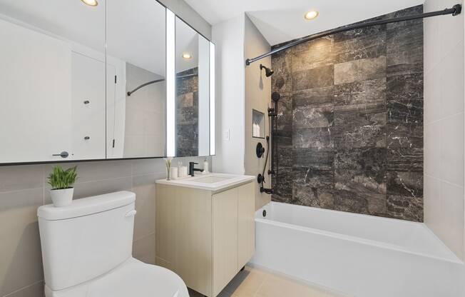 a bathroom with a white toilet and a shower and a sink at The Paxton, Brooklyn