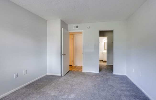 A room with a carpeted floor and a wooden door.
