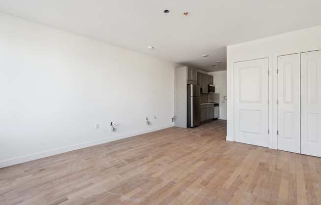 an empty living room with white walls and wood floors