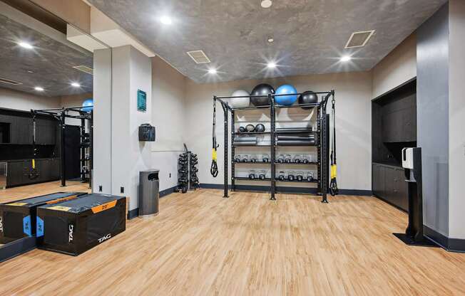 A gym with a wooden floor and a variety of equipment.